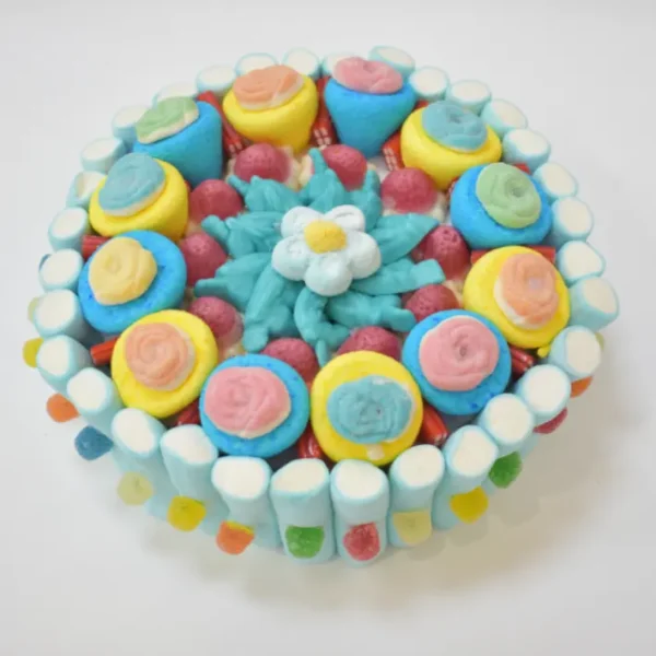 Detalle de la tarta de chuches con esponjitas en forma de flor y fresones rellenos, para compartir en el trabajo.