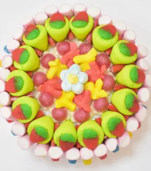 Tarta de chuches redonda con fresones rellenos y esponjitas en forma de flor, ideal para madres a la que les encanta las chuches.
