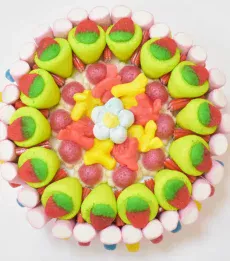 Tarta de chuches redonda con fresones rellenos y esponjitas en forma de flor, ideal para madres a la que les encanta las chuches.