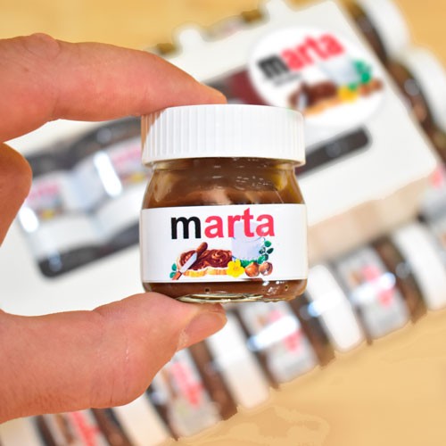 Tarro de Nutella personalizado con nombre. Van expuestos en un estuche de cartón blanco con ventana y el mismo logo con vinilo.