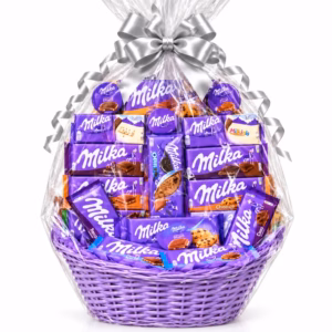 Cesta XXL de chocolates Milka con 18 productos, mimbre lila, envoltorio de celofán transparente y lazo plateado.