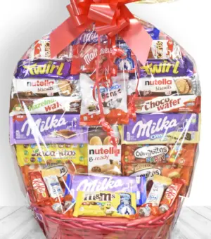 Cesta de chocolates Kinder, Milka y Nutella con lazo rojo decorativo, ideal para regalar.