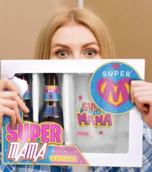 Mujer sosteniendo un estuche de regalo con dos botellines de cerveza y una jarra personalizada con el logo Super Mamá.