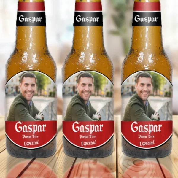 Detalle de botellines de cerveza personalizados con nombre "Gaspar" y foto sobre una mesa.