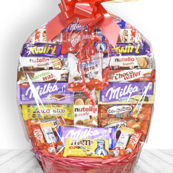 Cesta de chocolates Kinder, Milka y Nutella con lazo rojo decorativo, ideal para regalar.