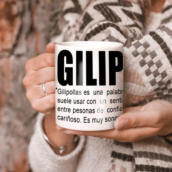 Persona sosteniendo una taza blanca con el texto "GILIPOLLAS", ideal para un regalo humorístico.