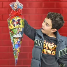 Cucurucho de chuches sin glute. agarrado por un niño modelo. Se ve el tamaño del cucurucho. e chuches.