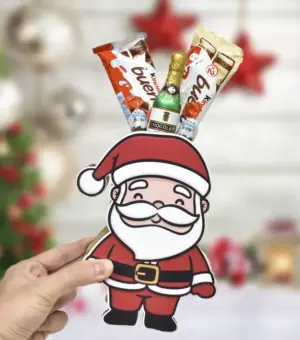 Mano sujetando un Papá Noel de madera con chocolates.