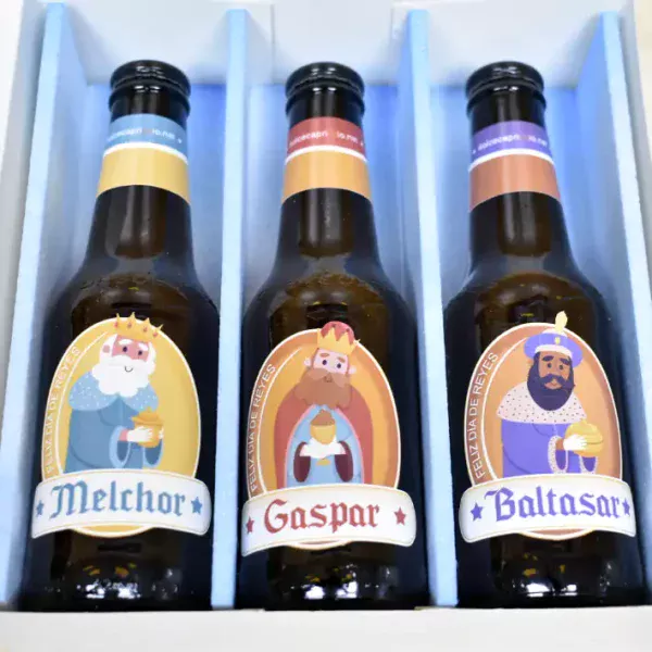 Estuche abierto con 3 cervezas dentro caracterizadas con los Reyes Magos. El estuche viene diseñado con los tres Reyes Magos y con la frase, Oro incienso y birra.