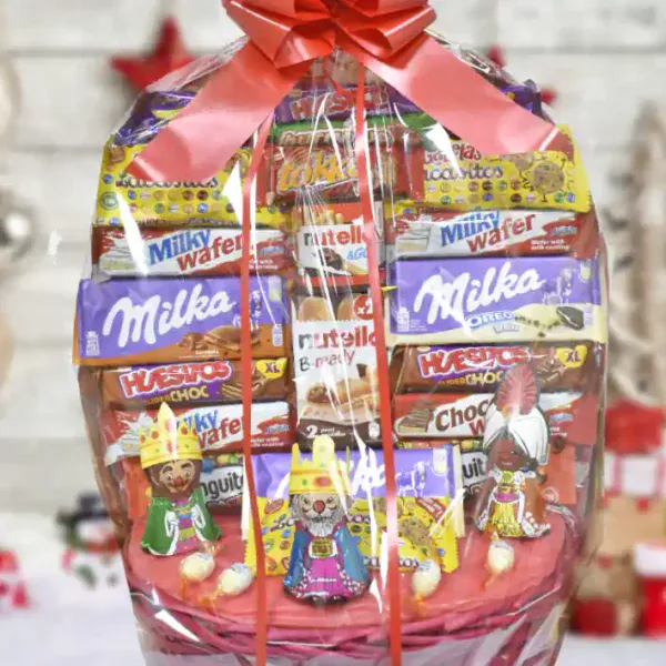 Cesta de chocolates surtidos con tres Reyes Magos de chocolate. La cesta viene preparada con Lazo y en una bolsa de celofán lista para regalar.