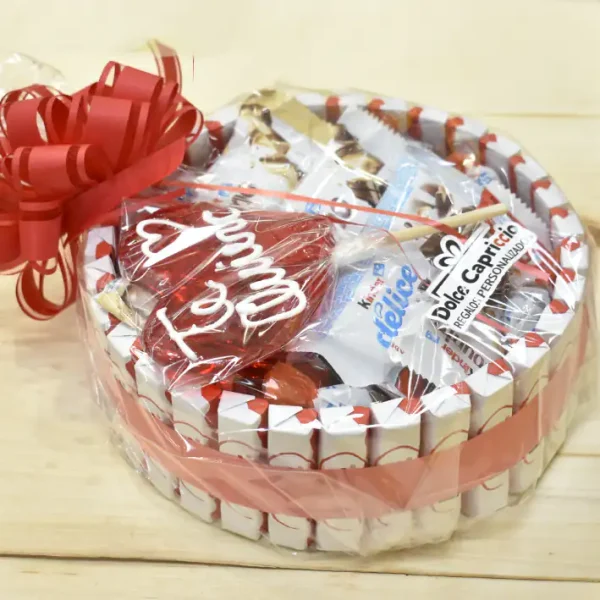 Tarta kinder con lazo rojo envuelta en papel celofán y una piruleta de Te quiero.