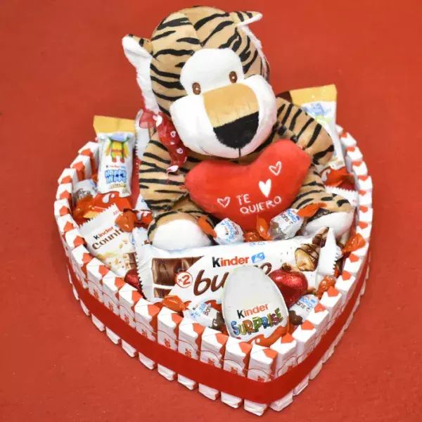 Tarta kinder en forma de corazón con un peluche arriba con un corazón que pone te quiero.