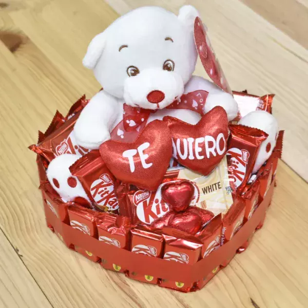 Tarta de corazón con kitkat y un oso de peluche con la palabra te quiero.