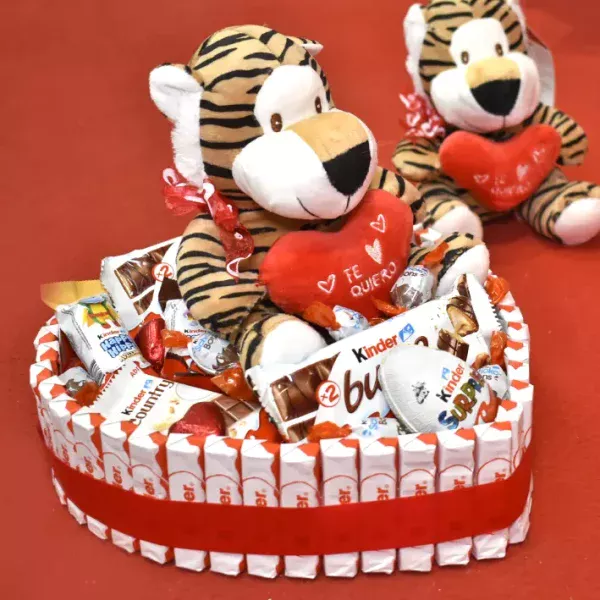 Tarta kinder en forma de corazón con un peluche arriba con un corazón que pone te quiero.