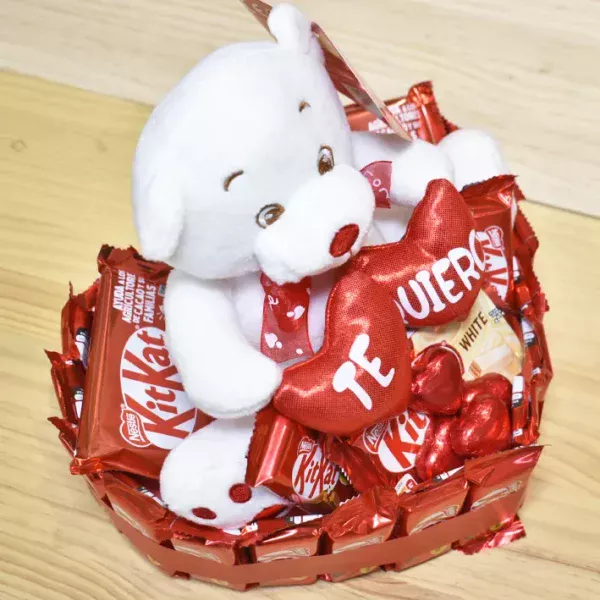 Tarta de corazón con kitkat y un oso de peluche con la palabra te quiero.