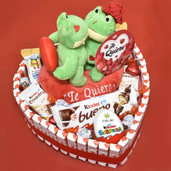 Tarta en forma de corazón repleta de kinder, con peluches de ranas besandose.