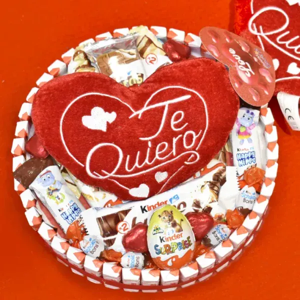 Tarta Kinder redonda con un peluche en forma de corazón.