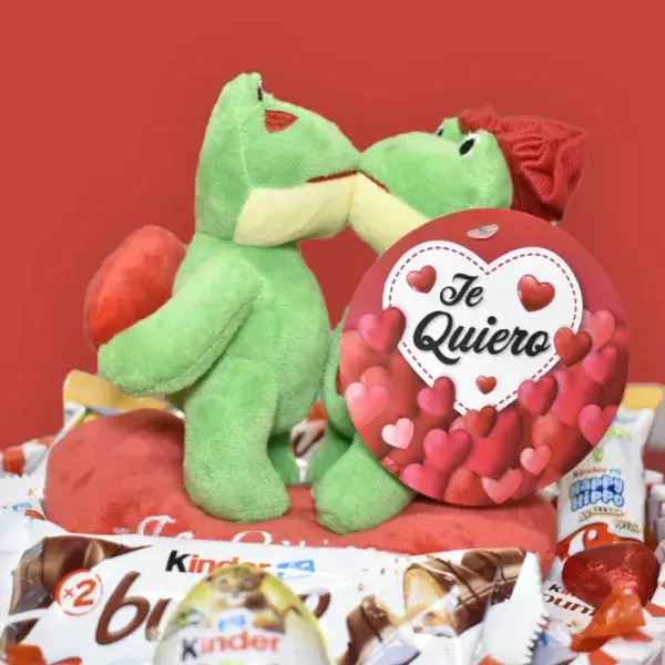 Ranas de peluche besándose encima de una tarta kinder en forma de corazón