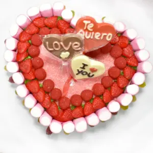 Tarta de chuches en forma de corazón. Fresas, moras lenguas y piruletas de chocolate.