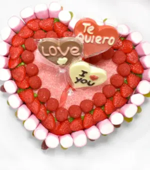 Tarta de chuches en forma de corazón. Fresas, moras lenguas y piruletas de chocolate.