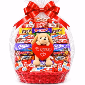 Cesta de chocolates para San Valentín con peluche de perrito y corazón rojo «Te quiero», envuelta en celofán transparente y decorada con un gran lazo rojo.