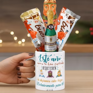 Taza tematizada de los Reyes Magos. Sujetada por una mano. Rellena con chocolates kinder entre otros y un rey de chocolate.