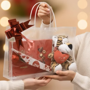 Bolso transparente. con Bombones Nestlé, rosa de chocolate y peluche de amor.