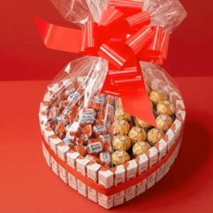 Cesta Kinder en forma de corazón con lazo y celofán en presentación premium.