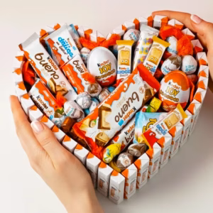 Manos sujetando cesta de chocolatinas Kinder en forma de corazón