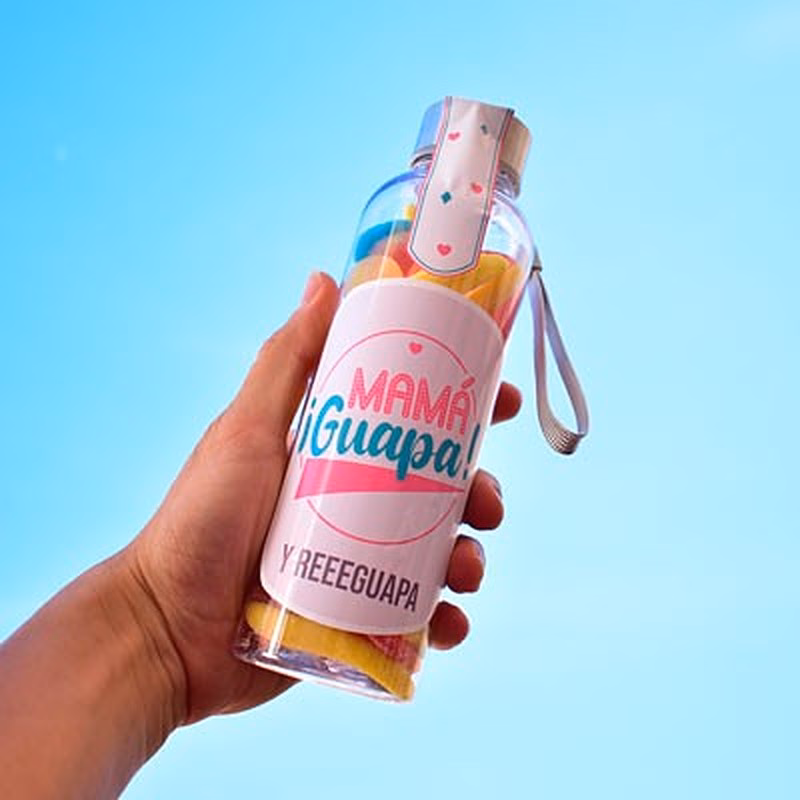 "Botella de chuches personalizada con mensaje para mamá guapa: una opción dulce y original para sorprender a tu mamá en cualquier ocasión. Disfruta de sus deliciosas golosinas y reutiliza la botella para llevar tus bebidas a cualquier lugar."